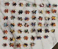 Overhead image of a grid of jigsaw puzzle pieces on a white marble background.